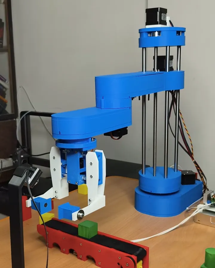 The SCARA arm I built, picking a coloured block above the conveyor in its final autonomous demo